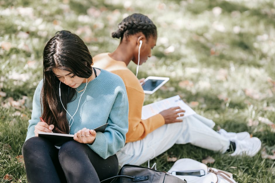 Multiethnic young students taking notes 